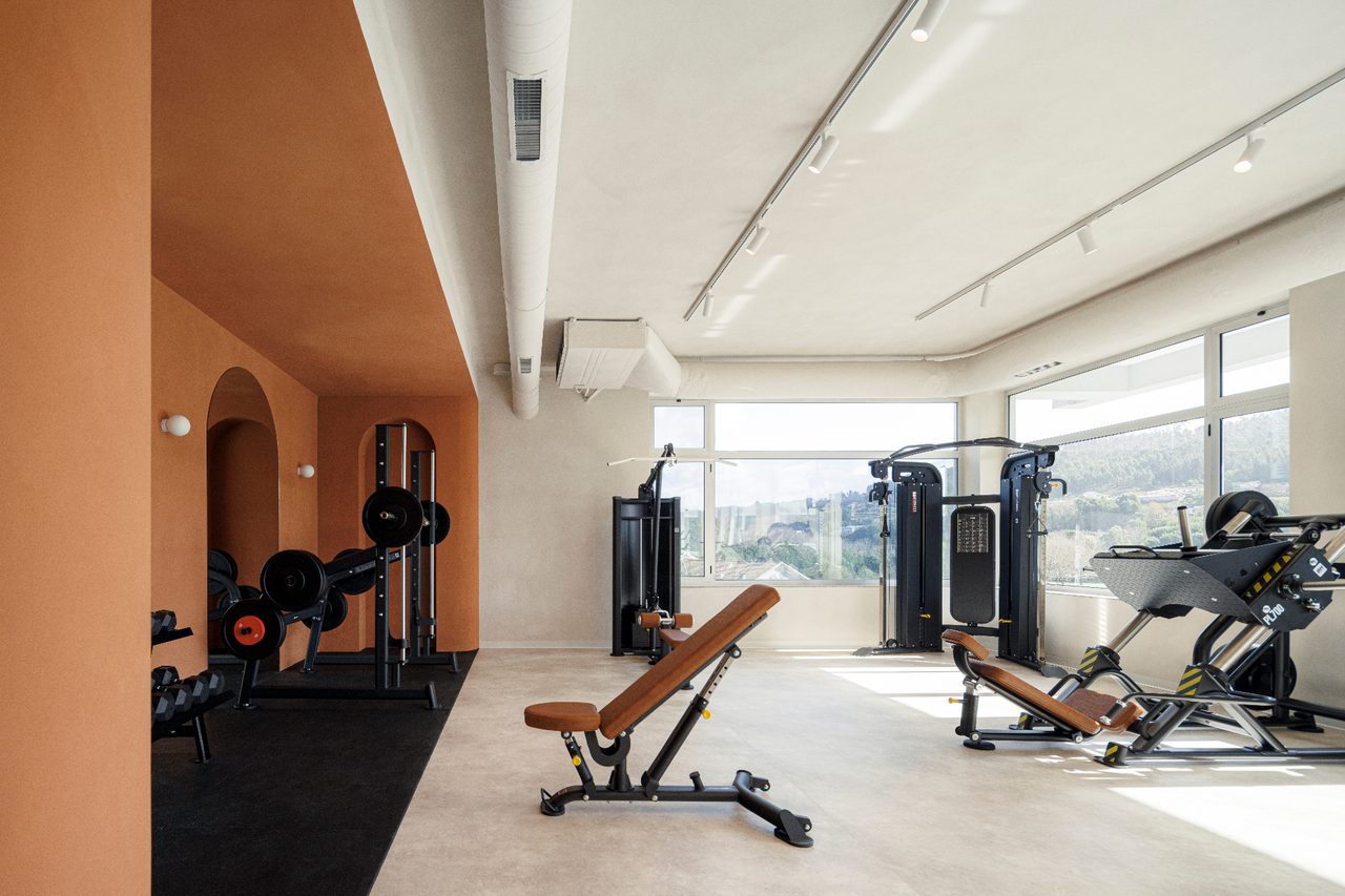 Commercial gym equipped by Geometrik, selectorized strength machines, free weights and cardio on technical rubber flooring